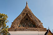 Wat Xieng Thong temple in Luang Prabang, Laos. The pointed arch brick and stucco shrine with inside is a standing Buddha statue. Detail of the pediment adorned with fine colourful glass mosaics. 